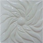 handmade ceramic tile with a high relief flower design and a one color glaze