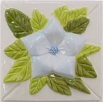 handmade ceramic tile with a high relief flower design and a multi-colored glaze
